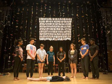 People surround Maren Bennett, 10, during a rehearsal of Cry Havoc Theater's Babel at the Winspear Opera House in Dallas on June 30. 
