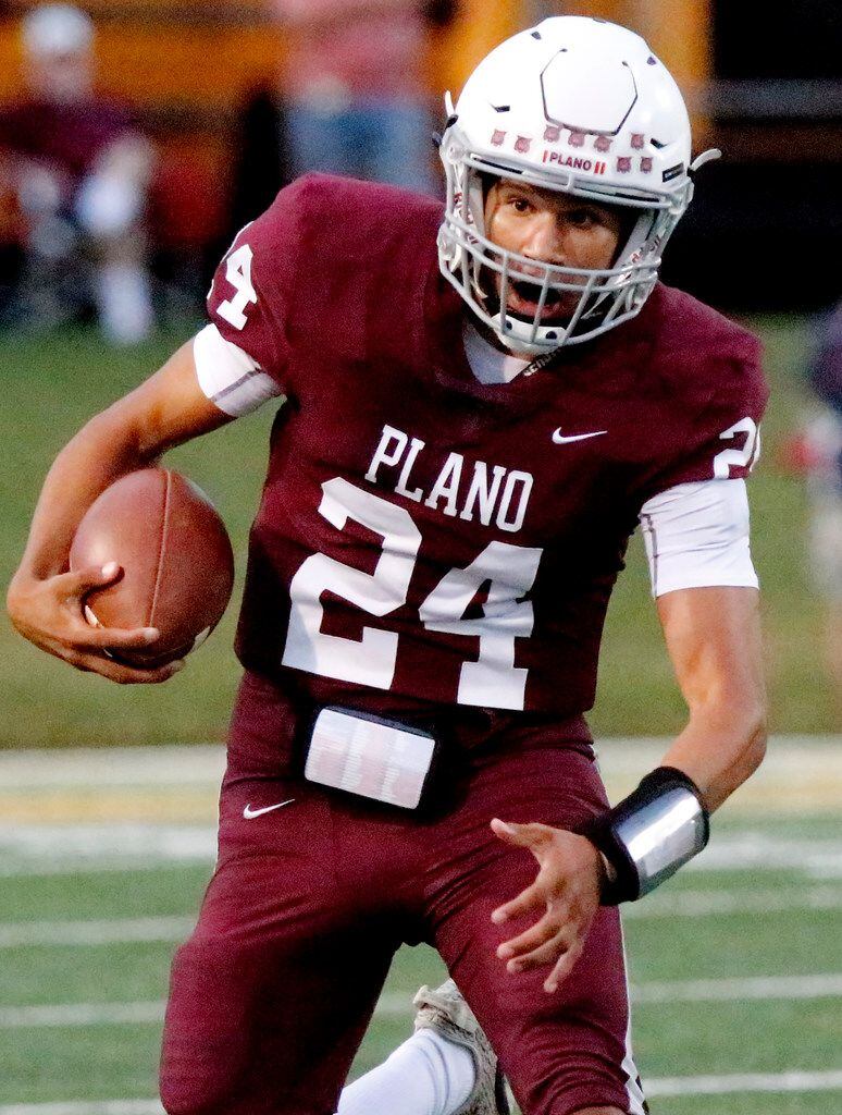Plano High School quarterback Oliver Towns (24) takes off with the football during the first...