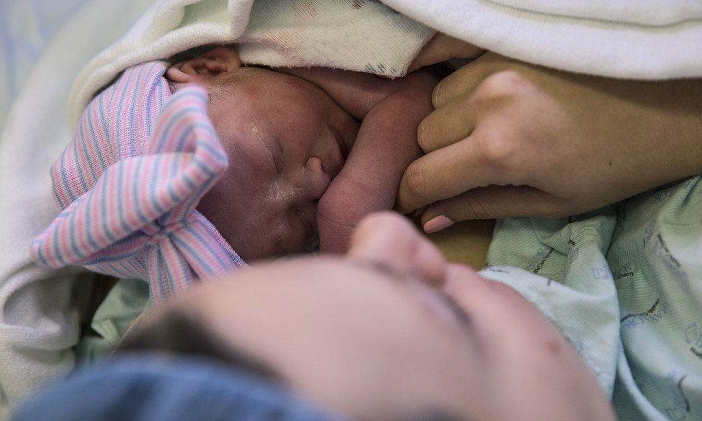 Mom holds her baby, only the second baby in the United States born from a mother who...