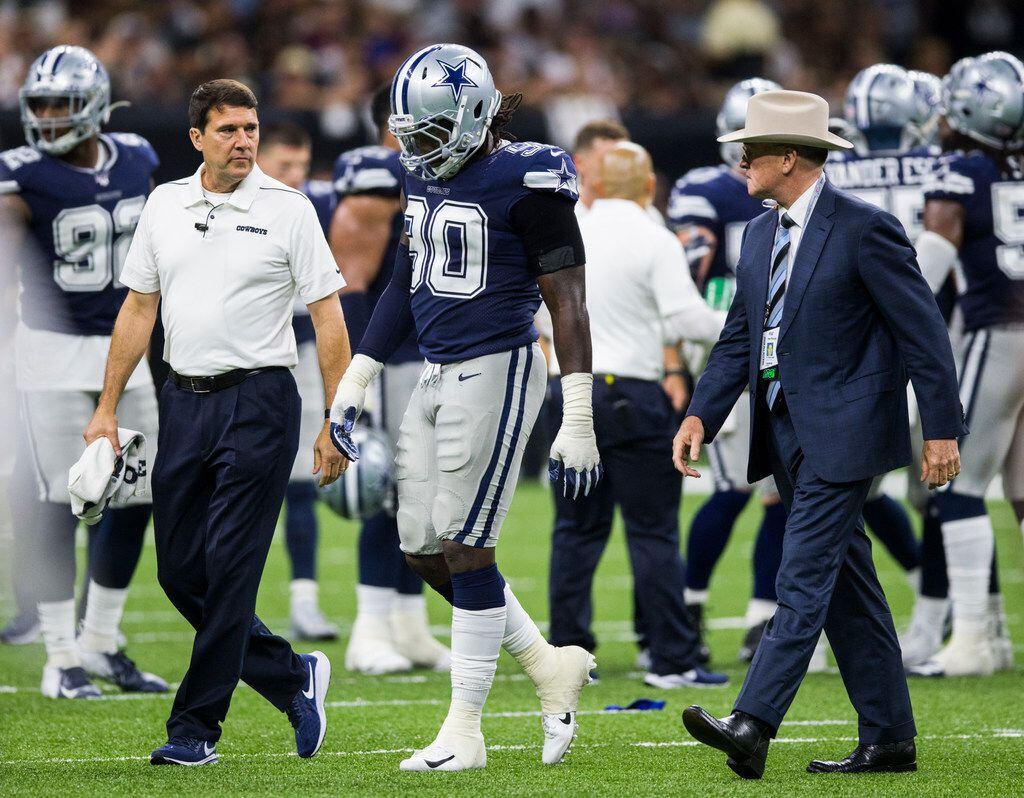 Dallas Cowboys defensive end Demarcus Lawrence (90) is escorted off the field after being checked out for injury during the fourth quarter of an NFL game between the Dallas Cowboys and the News Orleans Saints on Sunday, September 29, 2019 at Mercedes-Benz Superdome in New Orleans, Louisiana. (Ashley Landis/The Dallas Morning News)