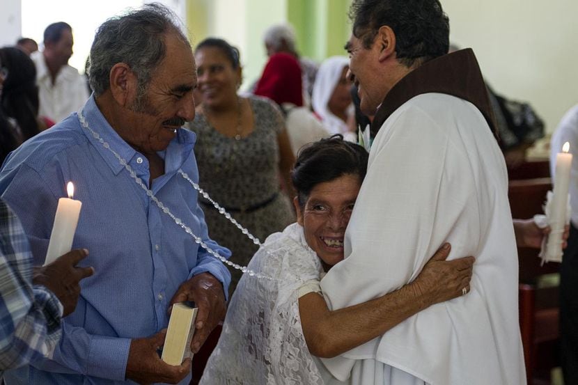 Francisca Santiago, de 65 años, abraza al sacerdote Domingo García Martínez, luego de la...