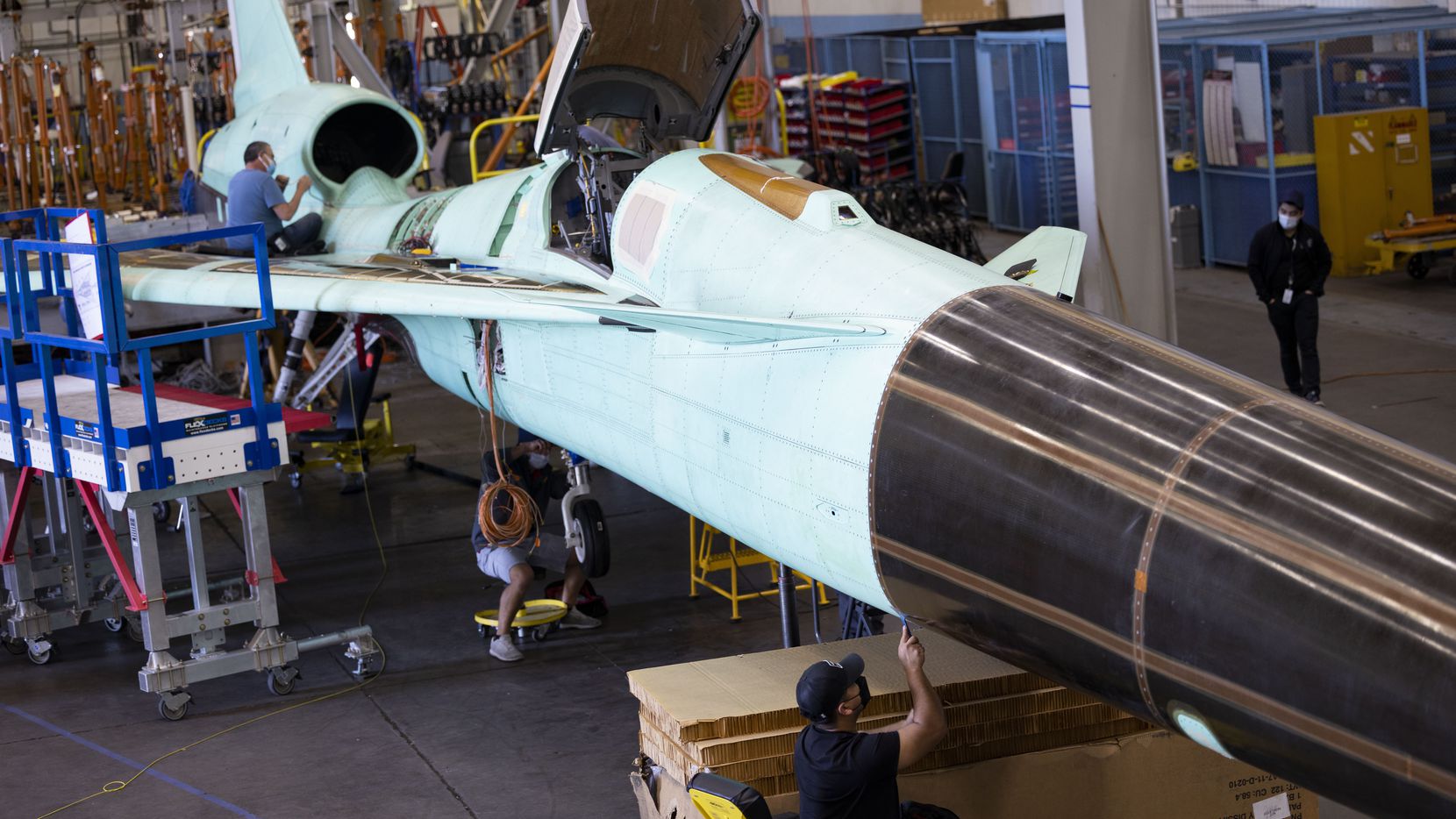 Technicians inspect the NASA X-59 QueSST (Quiet SuperSonic Technology) experimental aircraft...