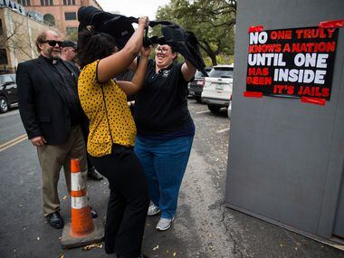 Legislative Aid Jennifer Russell of Houston (center) put on a protective vest like those used by correctional officers before stepping in to  a heated, mock prison cell outside the state capitol on Tuesday, March 12, 2019 in Austin. Texas Prisons Air-Conditioning Advocates set up the cell and challenged people to spend three minutes inside. 