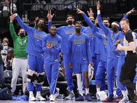 The Dallas Mavericks bench celebrates a first half dunk against the Phoenix Suns at the American Airlines Center in Dallas, January 20, 2022. 