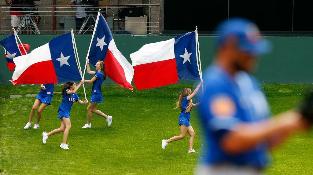 The Rangers Texas flag bearers race around the grassy knoll after Delino DeShields scored...
