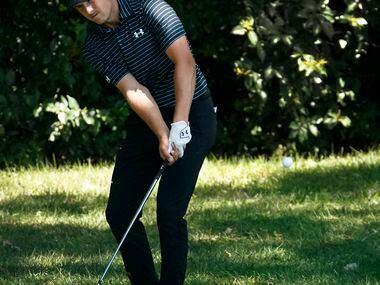 PGA Tour golfer Jordan Spieth uses a wedge to get on the 8th green after his tee shot went...