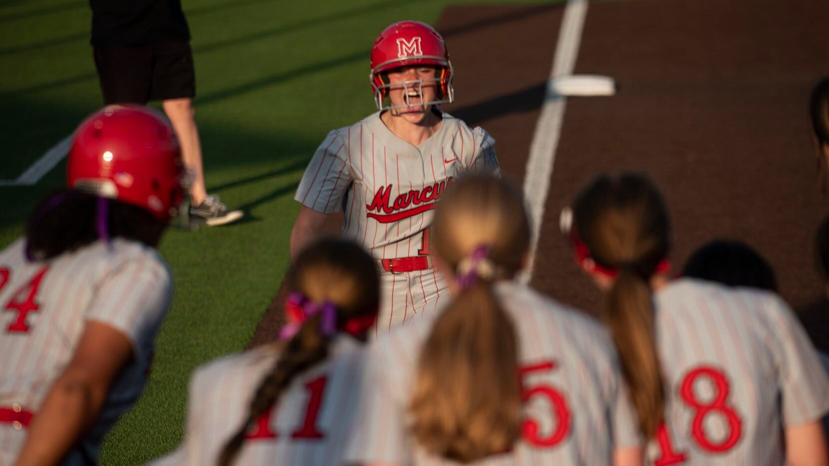 Flower Mound Marcus' Avery Rich is met at home plate by her teammates after hitting a solo...
