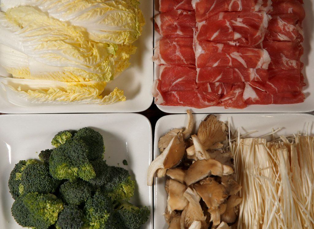 Trays of sliced lamb, mushrooms, cabbages and broccoli 