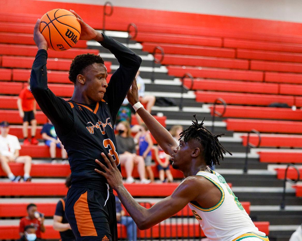 Madison forward Leonard Miles IV (3) defends against W.T. White guard Charles Fofanah (3) during the third quarter of a Dallas ISD Holiday Invitational basketball tournament game at Woodrow Wilson High School in Dallas, Tuesday, Dec. 28, 2021.