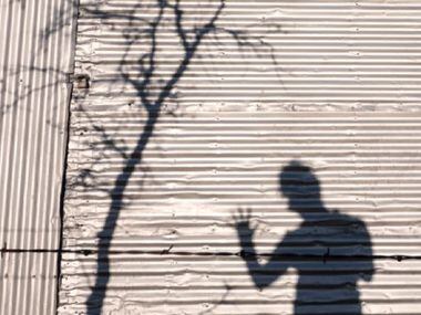 Courtney Perry photographs her own shadow on a metal barn near Celina, Texas Feb. 25, 2016.