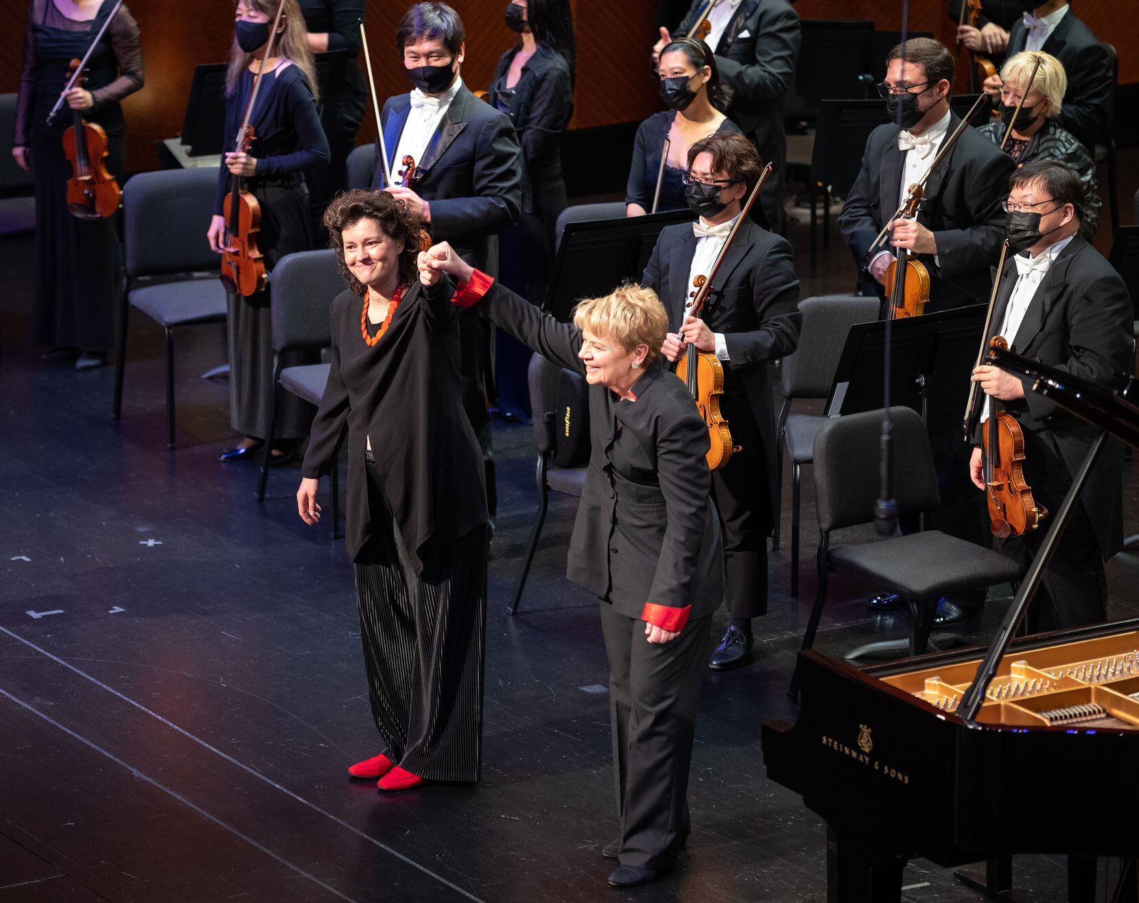 Anna Geniushene, 31, of Russia, with conductor Marin Alsop, right, stand for an applause...