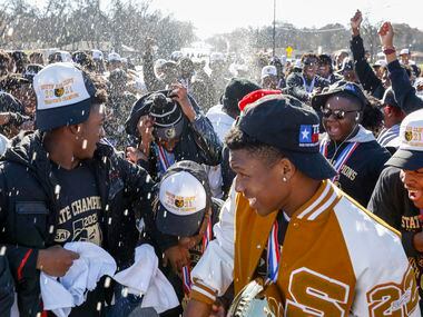Water is sprayed as members of the South Oak Cliff team celebrate during a parade...
