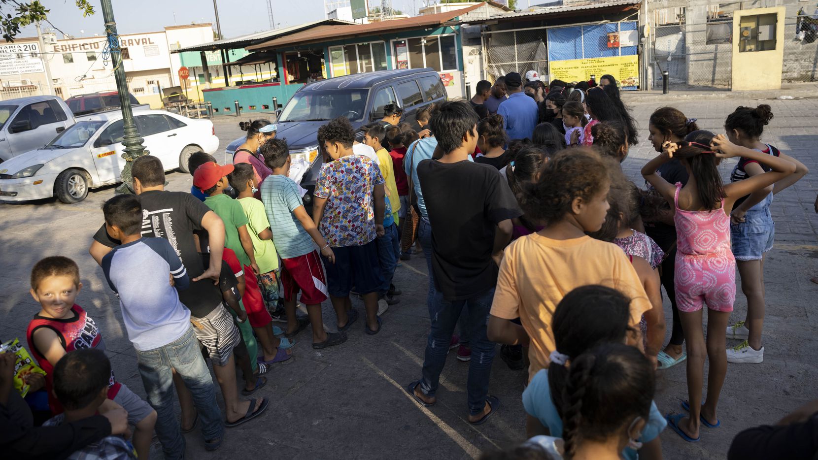 Un grupo de niños hace fila en una plaza de Reynosa, Tamaulipas, donde miles de mmigrantes...