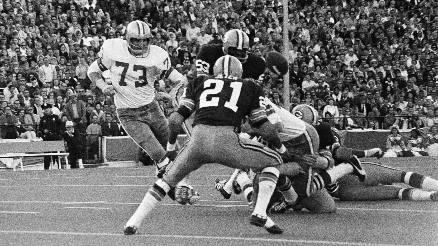 The ball squirts out of the hands of Dallas Cowboys Dan Reeves, right, as he is brought down...