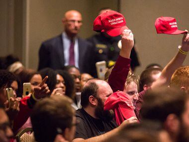 Supporters hold up Donald Trump "Make America Great Again" hats as Richard Spencer speaks at...
