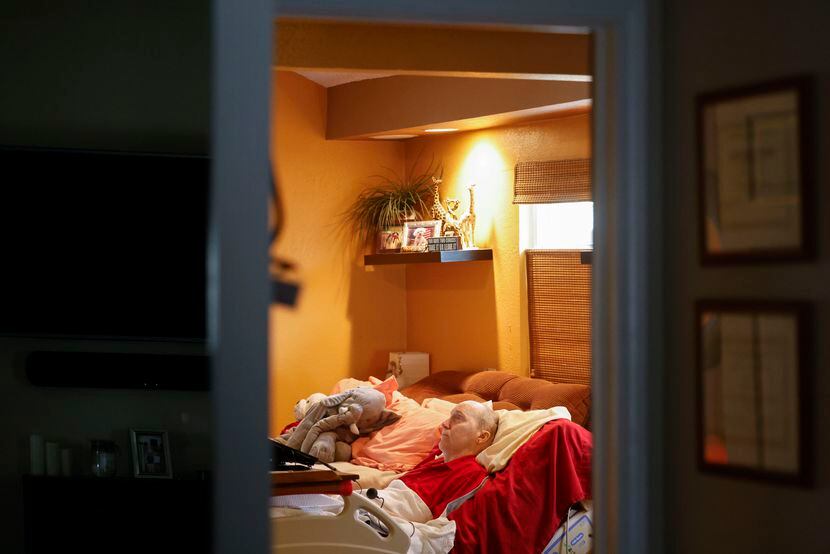 Rick Frame, 59, of Arlington, remains on his bed as his attendant Angela Blankenship (not in...