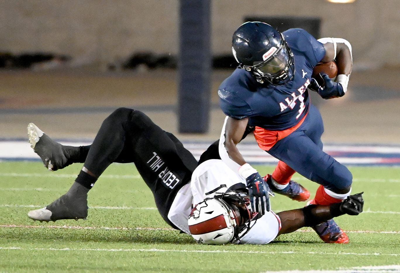 Allen's Kayvion Sibley (7) is tackled by Cedar Hill's Kylan Salter (22) in the second half...