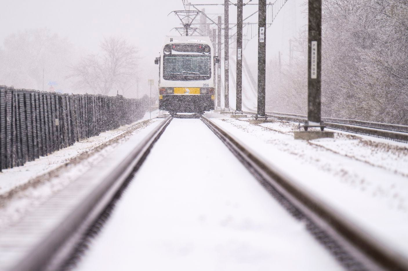 A DART rail train sits idle as snow covers the tracks between Spring Valley and Arapahoe...