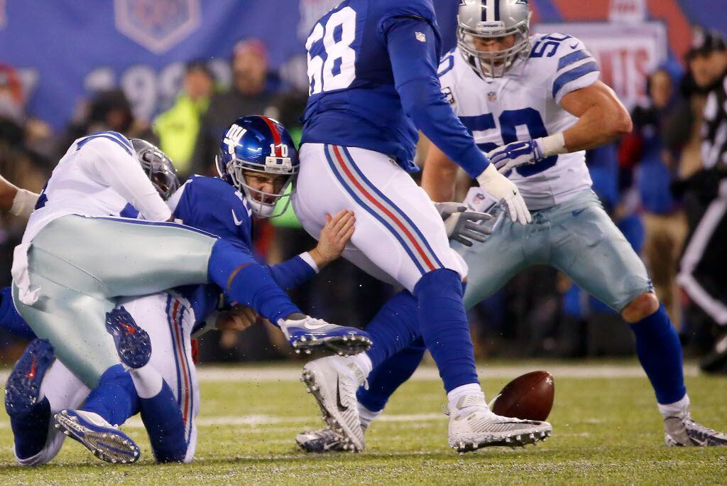 New York Giants quarterback Eli Manning (10) fumbles the ball as he's tackled by Dallas...