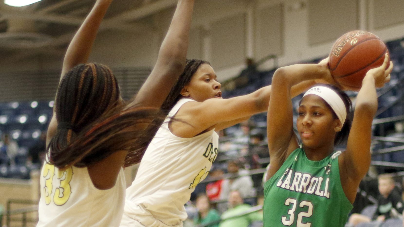 Southlake Carroll's Jillian Sowell (32) looks to pass as she faces the aggressive defense of...
