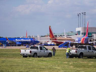 CP&Y, Inc. employees work as Southwest Airlines airplanes are parked at terminals while...