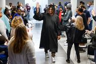 Artezz Coby Jay Watson waves as he walks down the aisle during a Homeless No More Program...