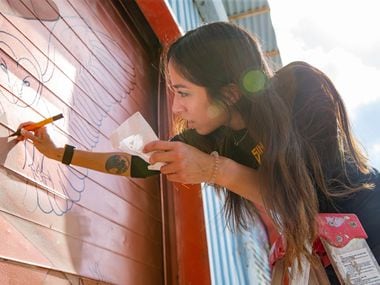 Artist Rose Rodriguez works on her mural on as part of The Wild West Mural Fest in Dallas on Thursday, Oct. 22, 2020. Rodriguez, a tattoo artist, was inspired by the Wichita people and their use of tattoos.