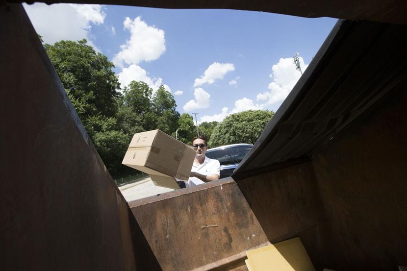 José Cavazos, de Dallas, bota material reciclable en un basurero para reciclaje en el parque...