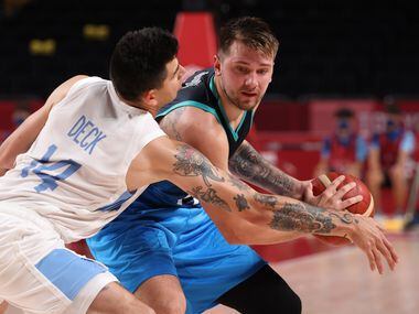 Slovenia’s Luka Doncic (77) is defended by Argentina’s Gabriel Deck (14) during the...