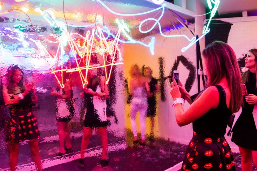 Visitors to a pop-up art installation take selfies.