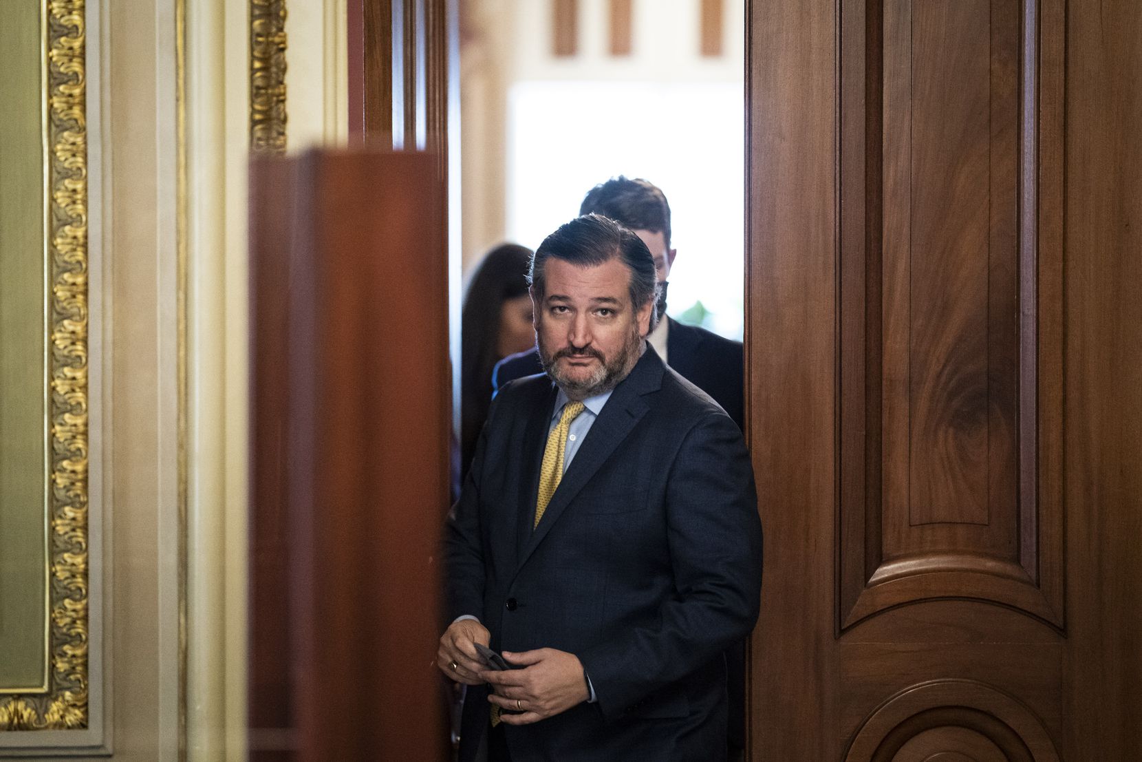 Sen. Ted Cruz, R-Texas, walks out of a meeting room for Donald Trump's lawyers and back to the Senate floor through the Senate Reception room on the fourth day of Trump's impeachment trial, Feb 12, 2021.