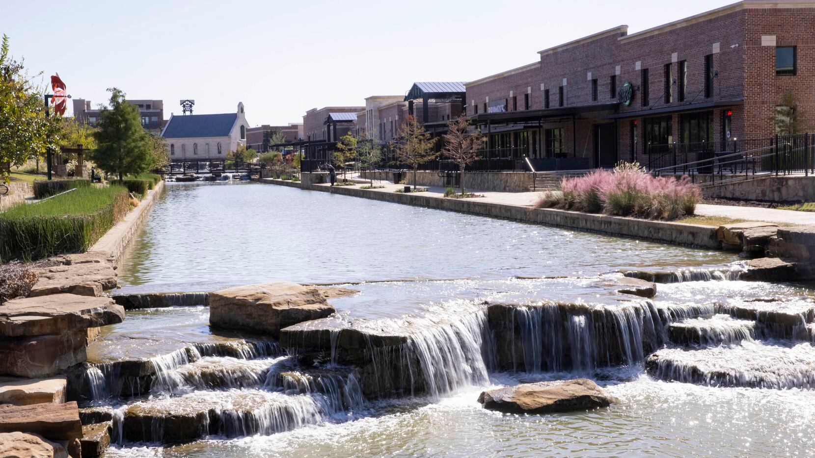 The River Walk at Central Park is a manmade water feature tucked behind the intersection of Cross Timbers and Long Prairie roads in Flower Mound. In the red brick building on the right, the developer has installed five restaurants and bars. On the left (not pictured) is a new residential area.