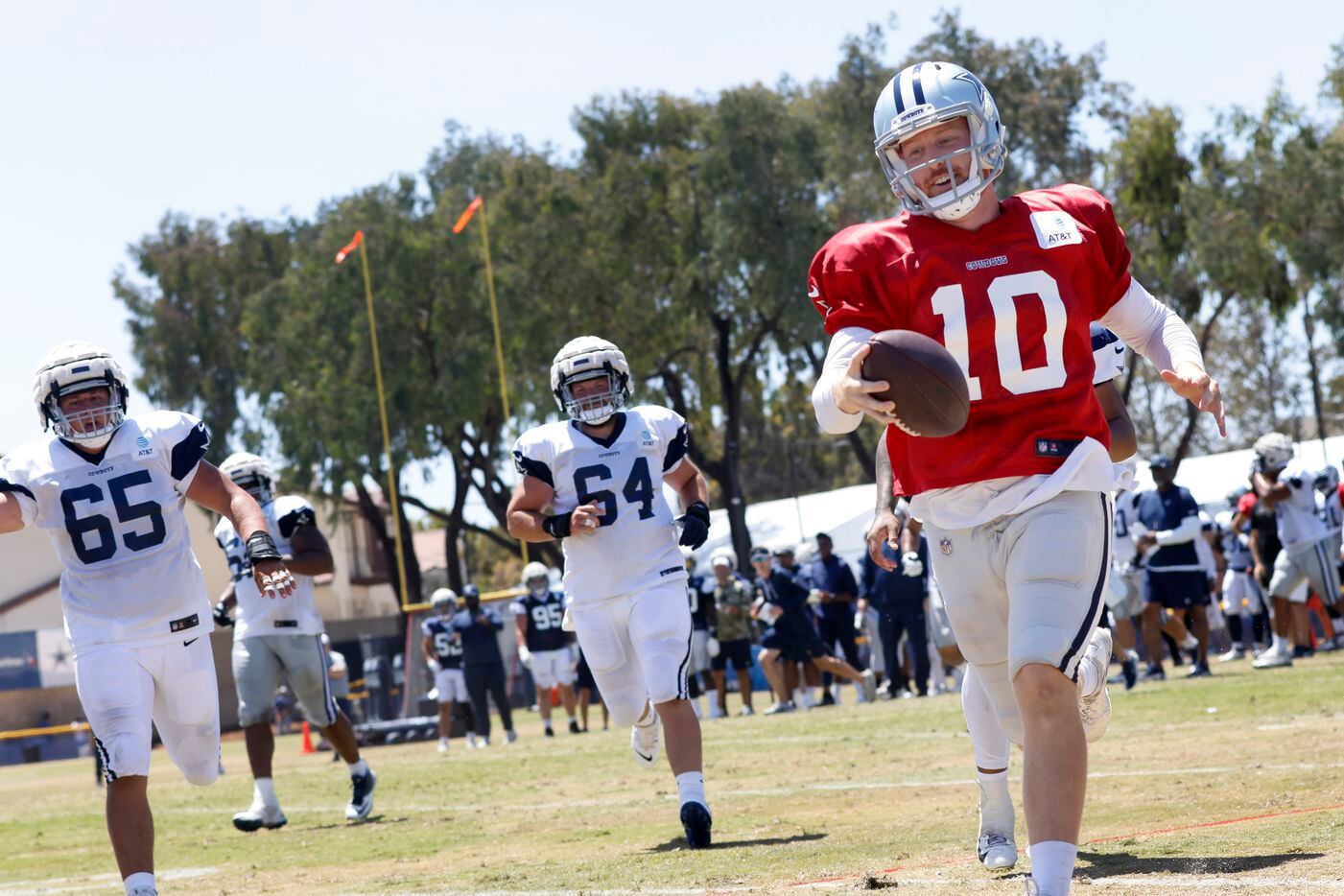 Dallas Cowboys quarterback Cooper Rush (10) reaches for the first down marker as he kept the...