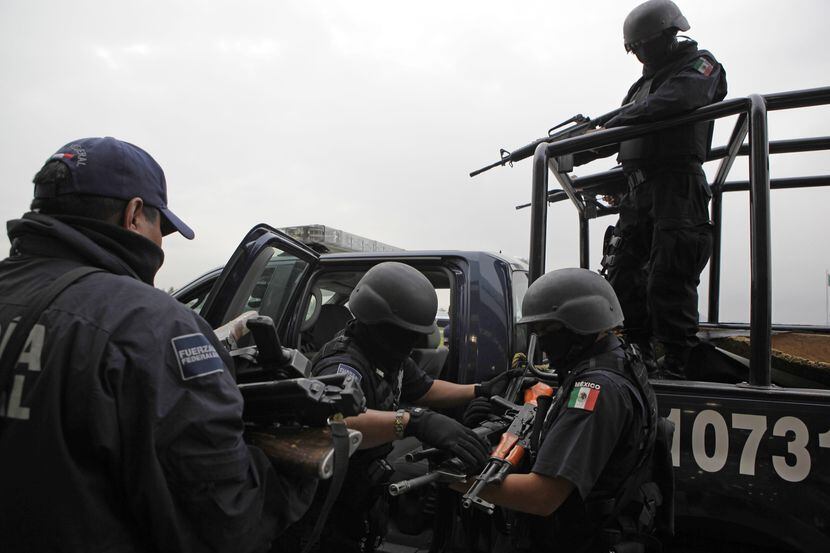 ARCHIVO – En esta fotodel 26 de junio de 2009, se recuperan armas de presuntos miembros del...