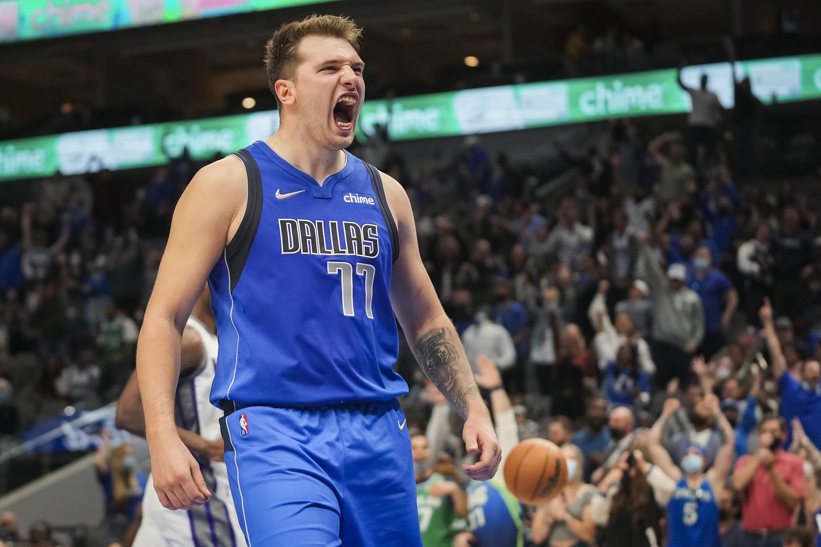 Dallas Mavericks guard Luka Doncic celebrates after feeding forward Dorian Finney-Smith for a breakaway dunk during the second half of a game against the Sacramento Kings at American Airlines Center on Oct. 31, 2021.