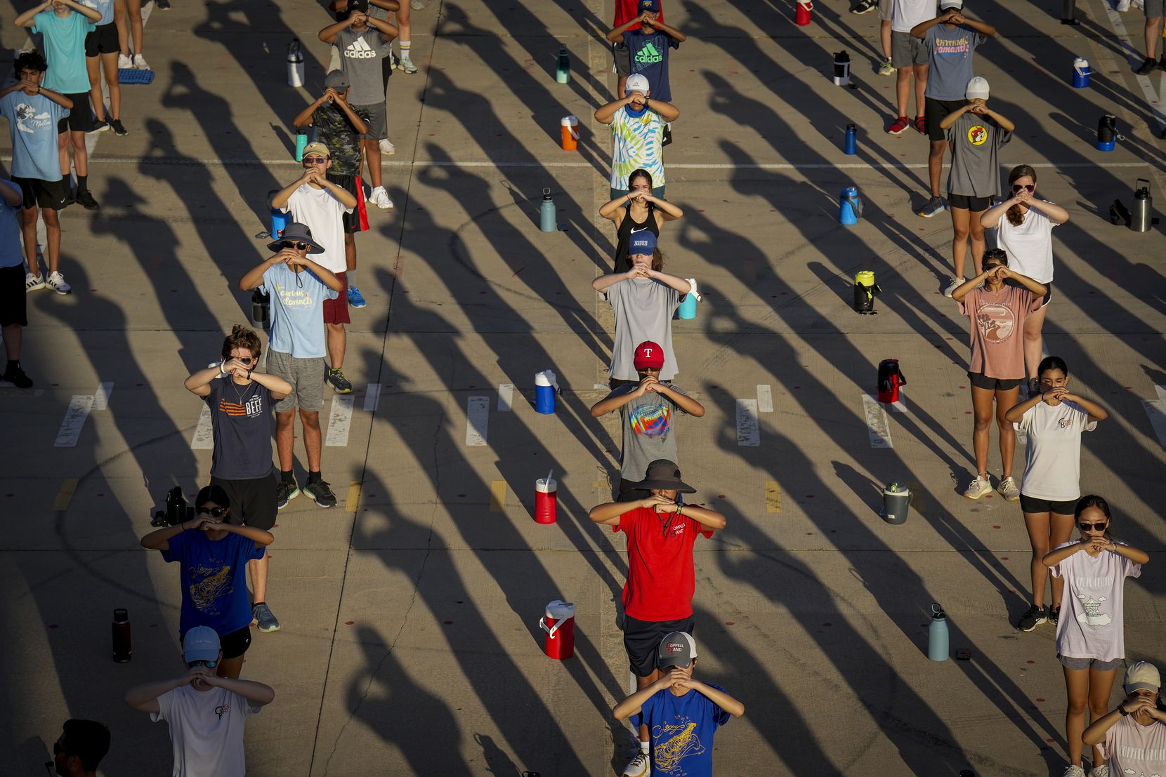Morning shadows fall across members of the Coppell marching band during a morning practice...