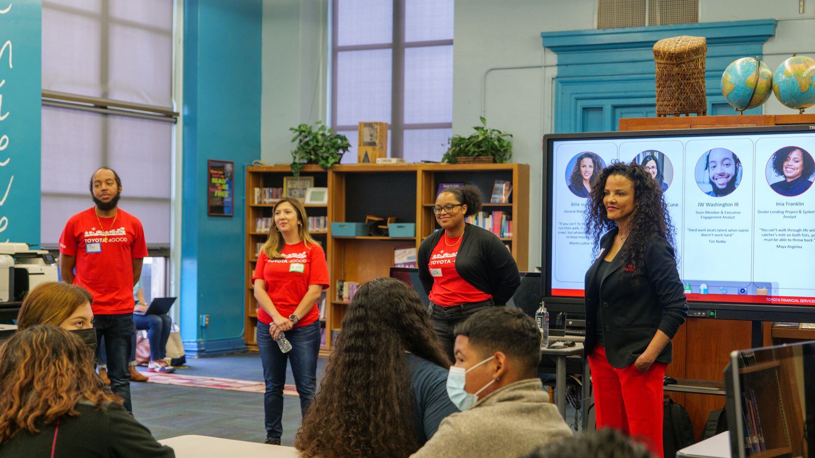 Volunteers present to a group of students during a career day event