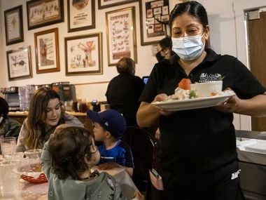 Dora Calderon serves customers at Los Vaqueros Restaurant in Fort Worth last month. Unemployment rates for Hispanics and Blacks in Texas remain much higher than for whites and have not been declining in the same fashion, according to a recent Dallas Fed article. (Lynda M. González/The Dallas Morning News)
