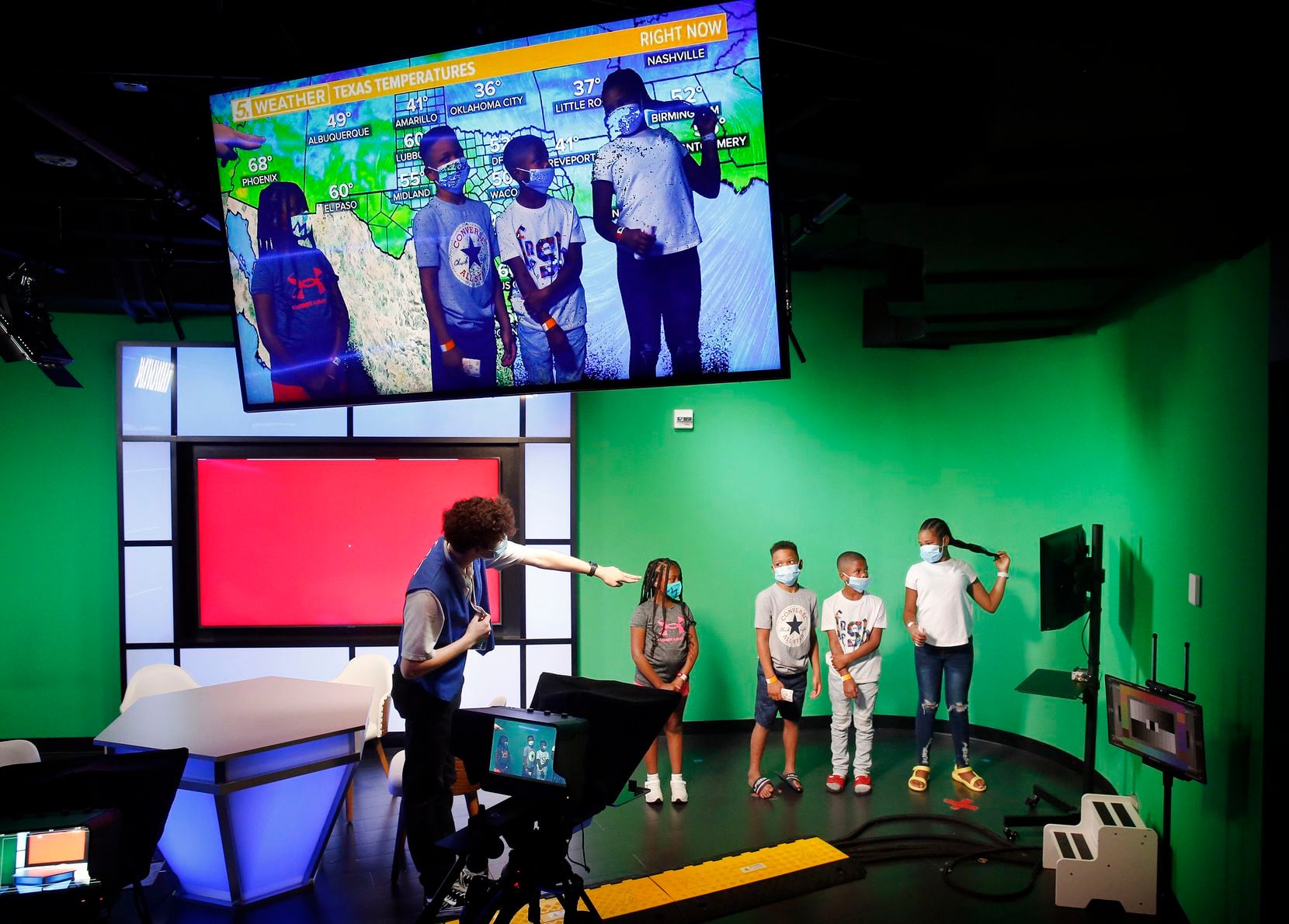 Los niños se paran frente a una pantalla verde mientras entregan pronósticos del tiempo en el estudio de televisión para niños WFAA en KidZania Dallas, la única ubicación de la compañía en los EE. UU. En Stonebriar Mall en The Bridges en Plano, Texas, el 16 de julio de 2021 (Tom Fox / The Dallas Morning News)