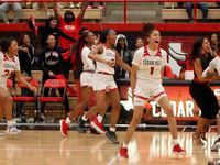 Cedar Hill head coach Nicole Collins celebrates with her players in front of the team bench after their 81-72 overtime victory over Duncanville. The two teams played their District 11-6A girls basketball game at Cedar Hill High School in Cedar Hill on January 14, 2022.