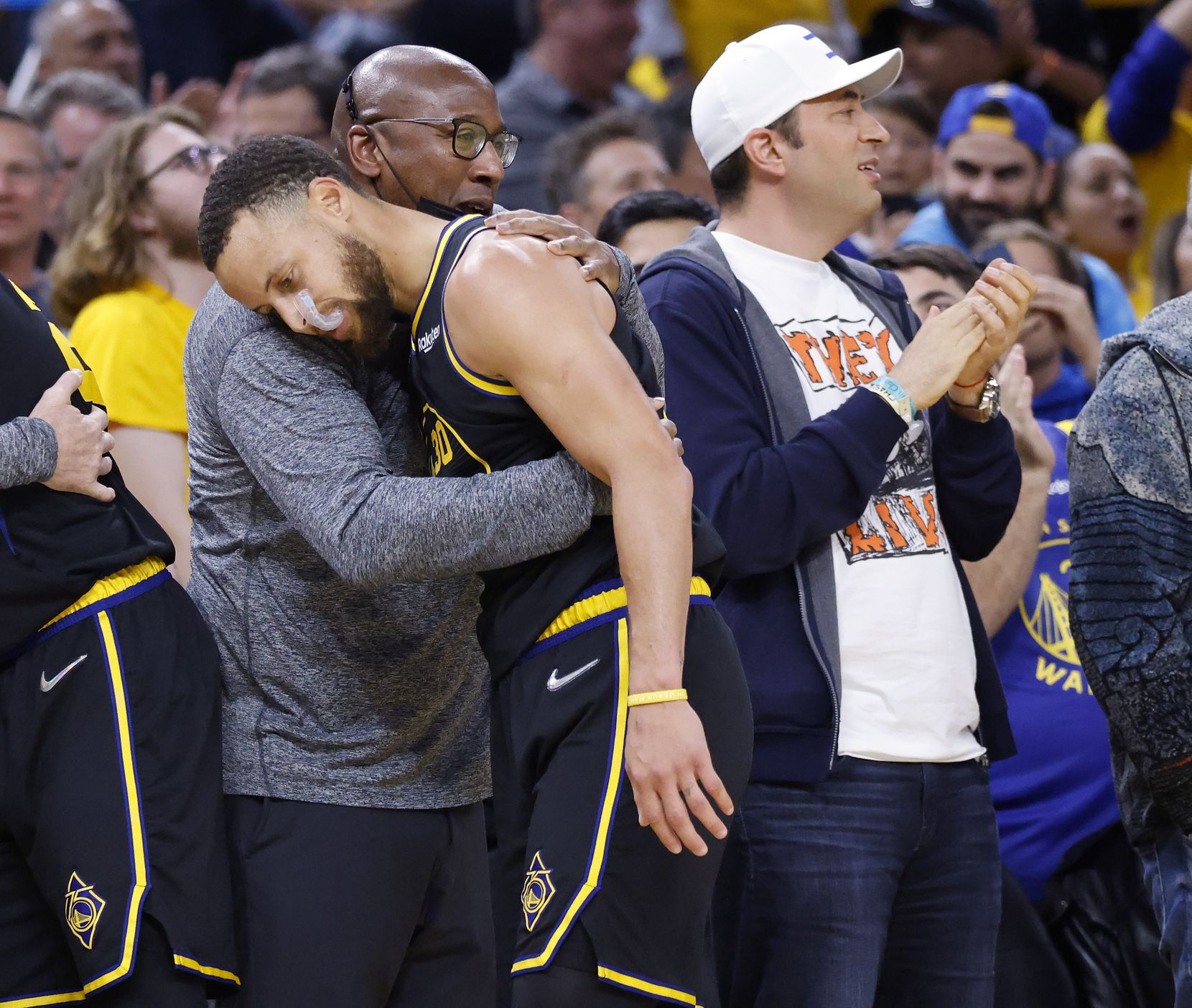 Golden State Warriors guard Stephen Curry (30) is congratulated by assistant coach Mike...