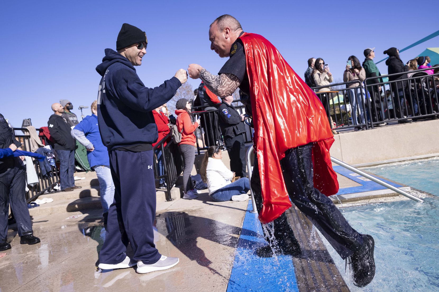 Richard Foy, deputy chief with the Dallas Police Department, fist bumps Chief Eddie García (left) as he comes out of the water after participating in the Special Olympics Polar Plunge on Saturday, Jan. 29, 2022, in Mesquite, TX. 