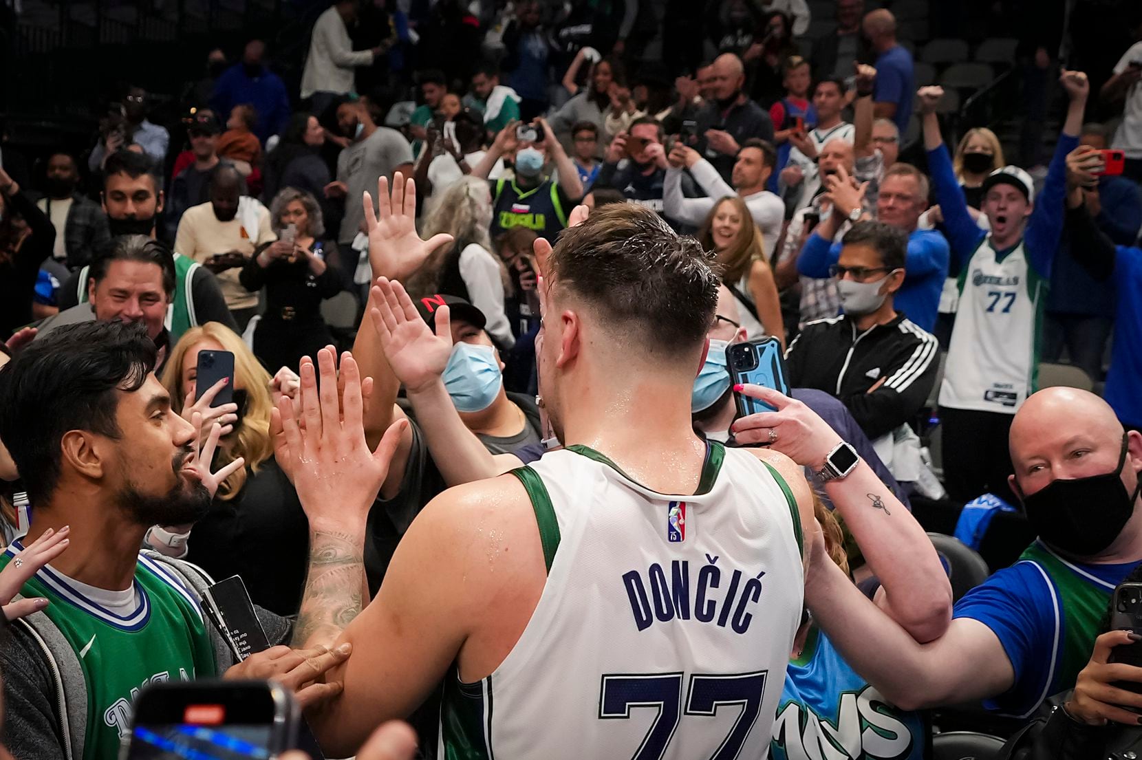 Dallas Mavericks guard Luka Doncic (77) celebrates with fans after hitting a 3-pointer at...