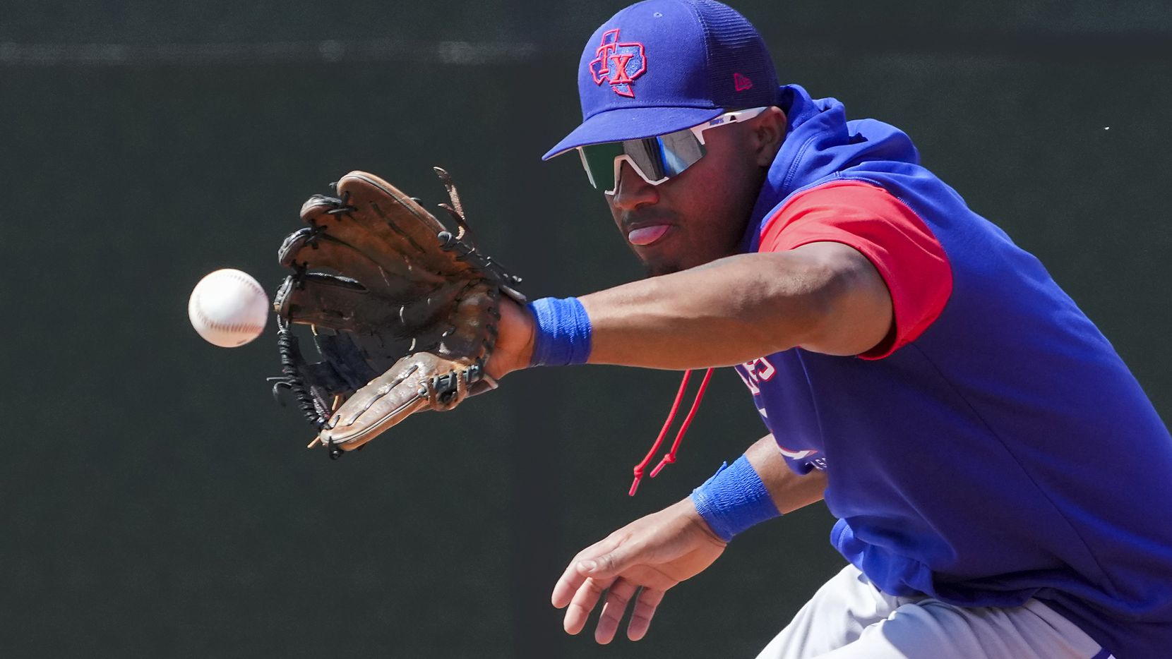 Texas Rangers infielder Andy Ibáñez fields a grounder during a spring training workout at...