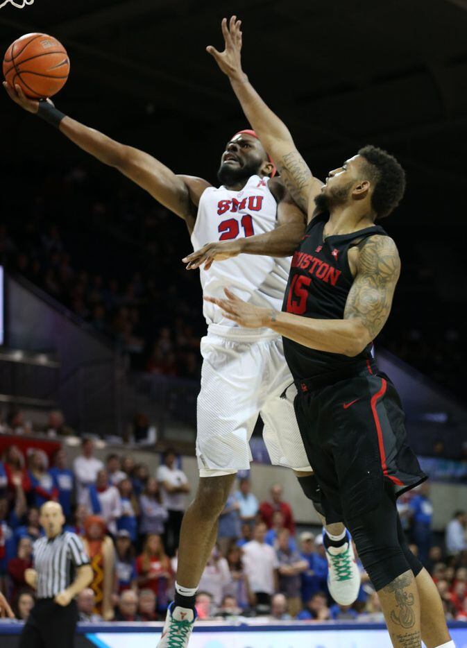 Southern Methodist Mustangs guard Ben Emelogu II (21) lays up a shot against Houston Cougars...
