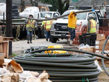 Construction workers unload gas pipes in a neighborhood of northwest Dallas on Thursday....