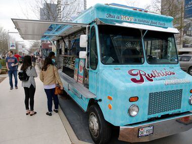 Customers wait to give their order at Ruthie's Rolling Cafe food truck at Klyde Warren Park...
