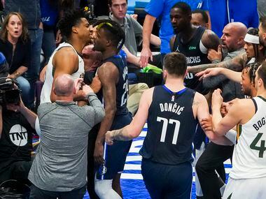 Players coaches and referees try to separate Dallas Mavericks forward Dorian Finney-Smith...