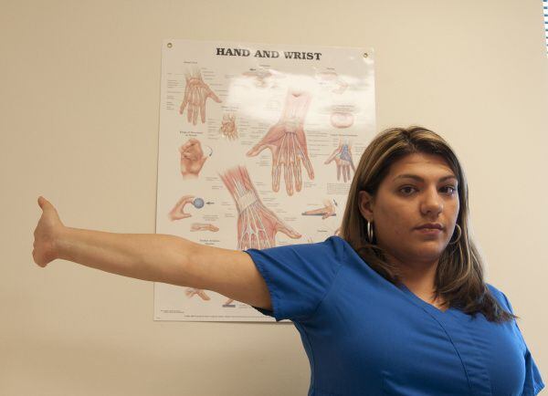 Brenda Alvarez demonstrates Step 11 of an arm exercise to alleviate hand pain.