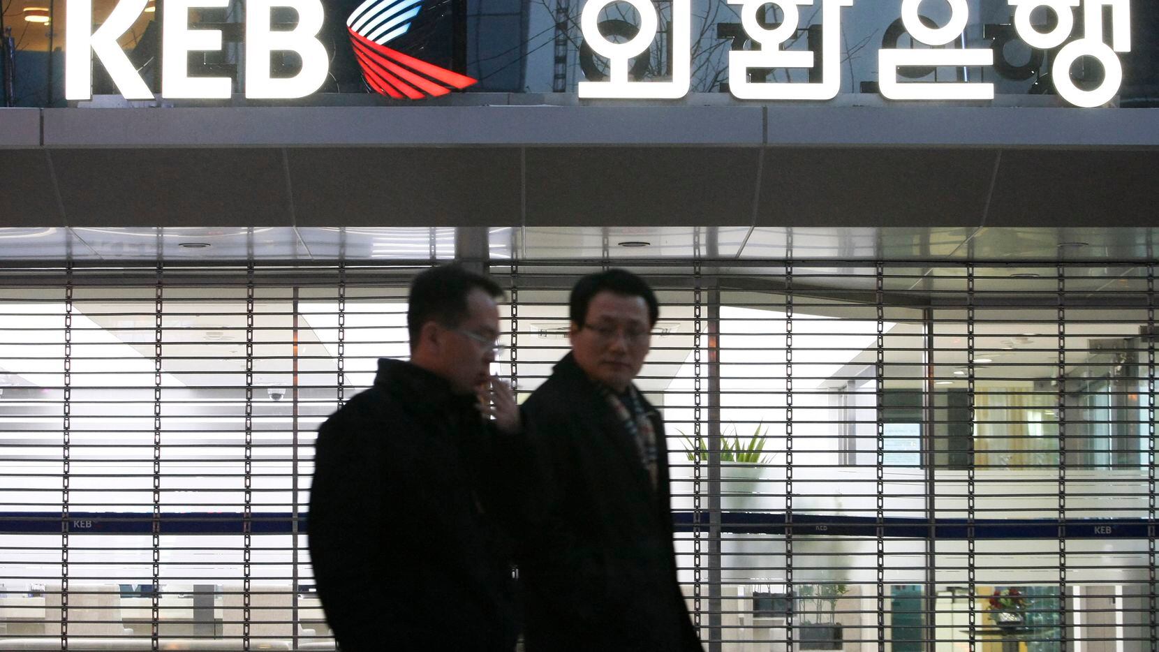Customers walk by Korea Exchange Bank headquarters in Seoul, South Korea. The government...